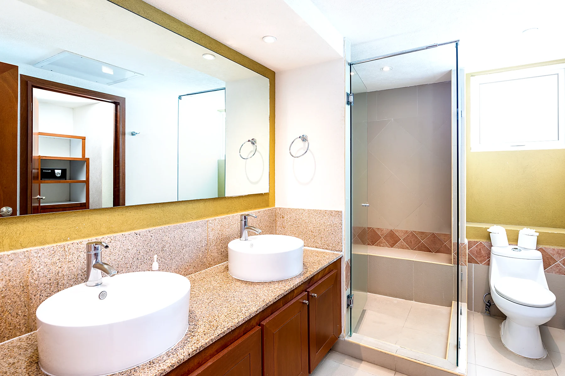 Baño principal con doble lavabo de piedra, tina y regadera de cristal