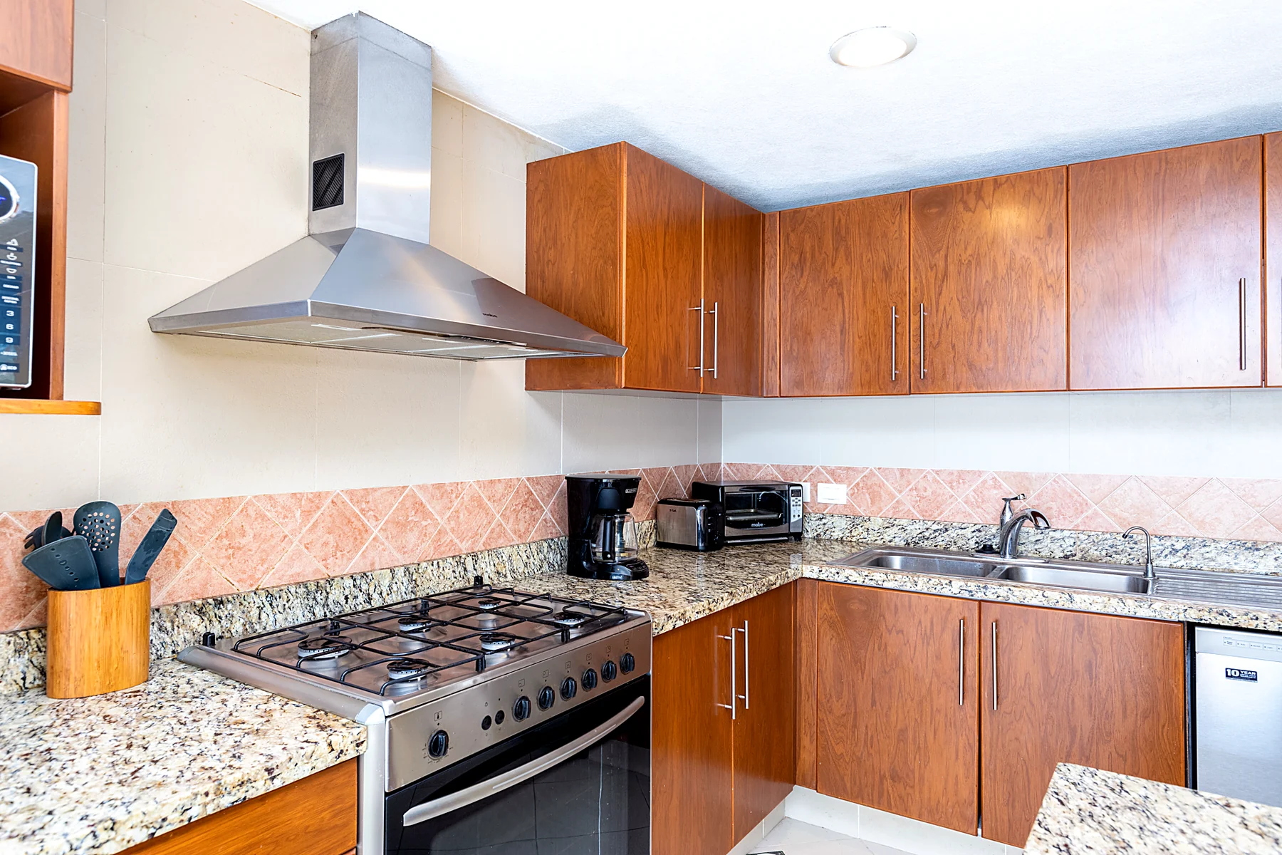 Cocina completa de gas con estufa, campana y barra de granito