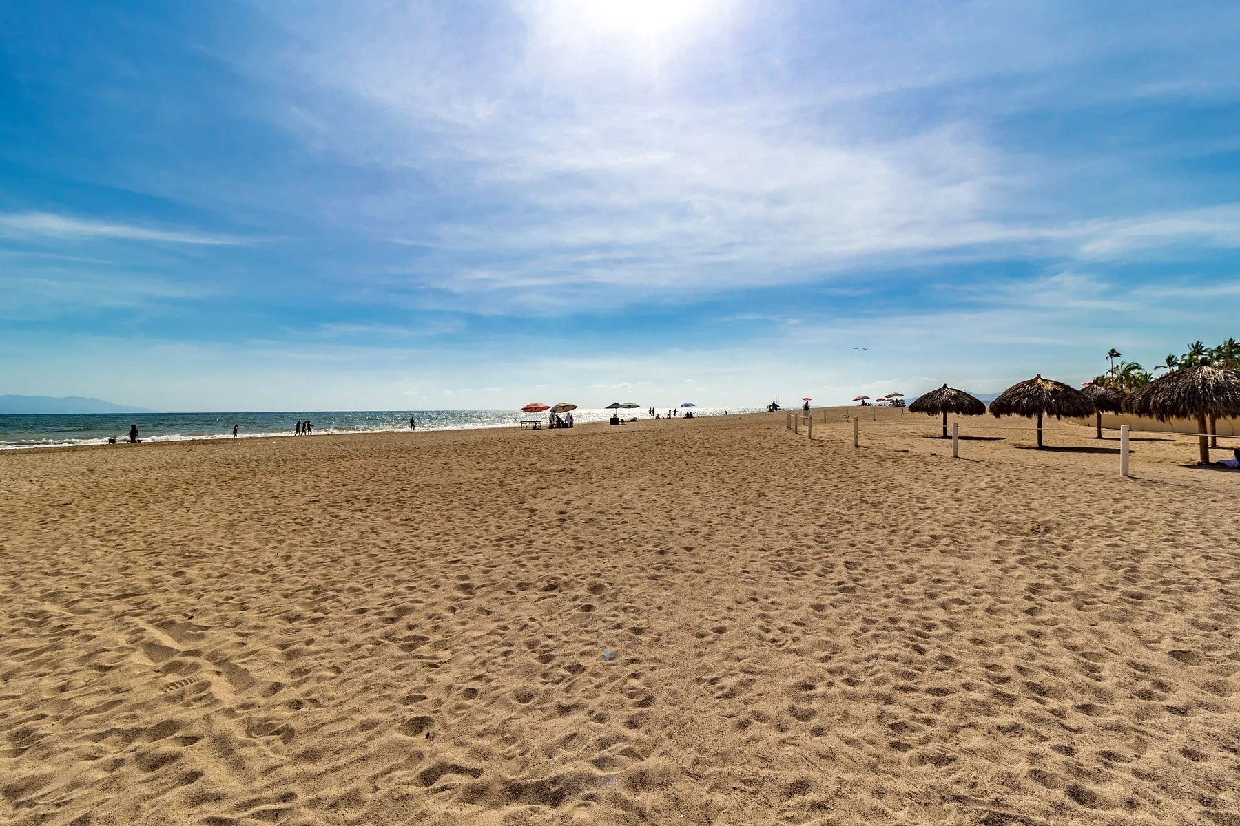La playa abierta frente al Grand Venetian, con palapas