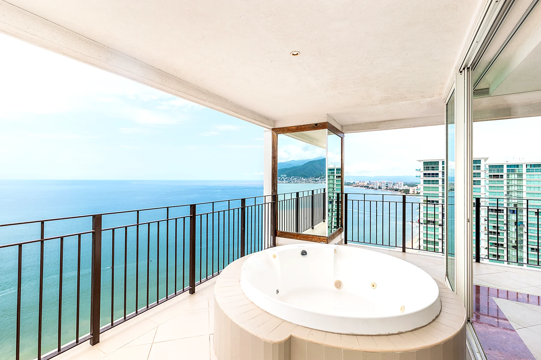 El jacuzzi de la terraza, con el mar abierto y la sierra al fondo