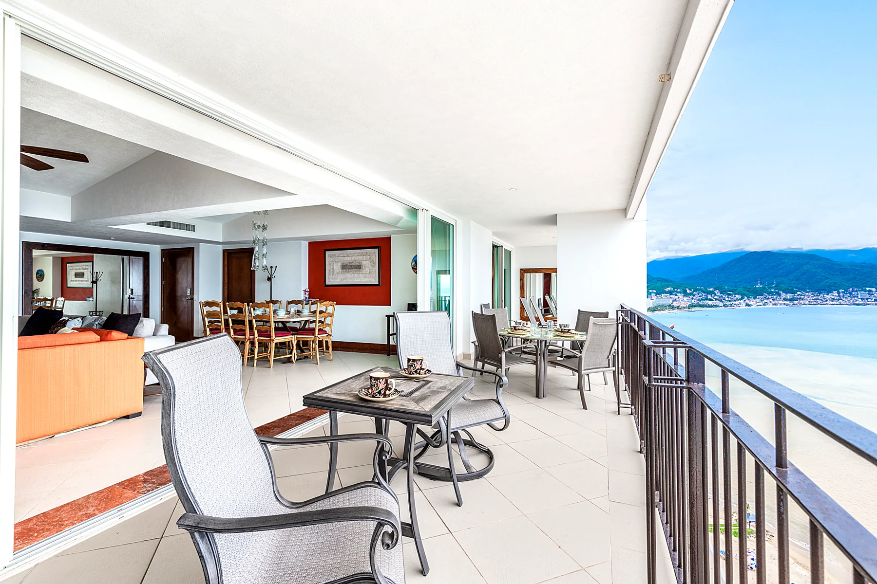 La terraza con las mesas de desayuno y la bahía al fondo